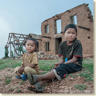 Kinder vor ihrem durch die Erdbeben zerstörten Haus
